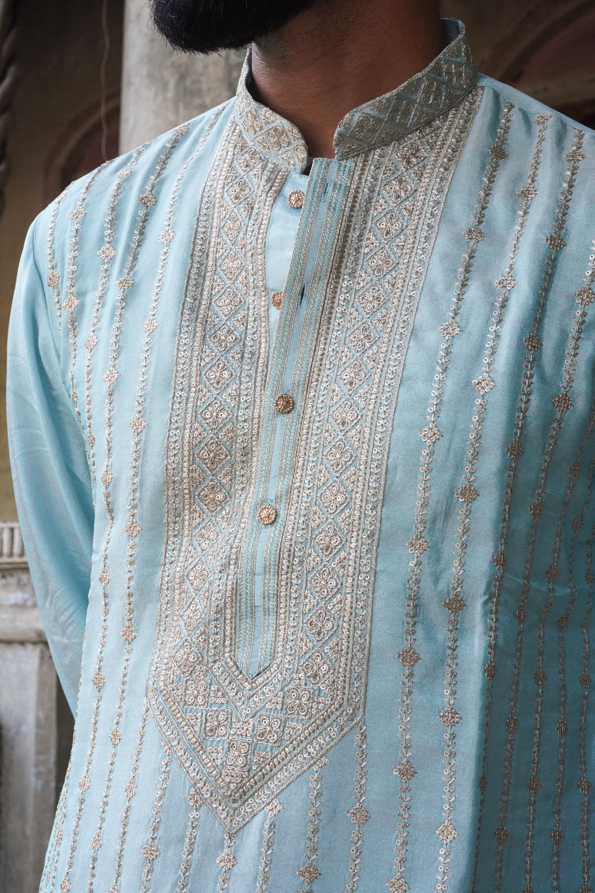 Close-up of embroidered yoke, collar and rose-gold buttons on light blue kurta