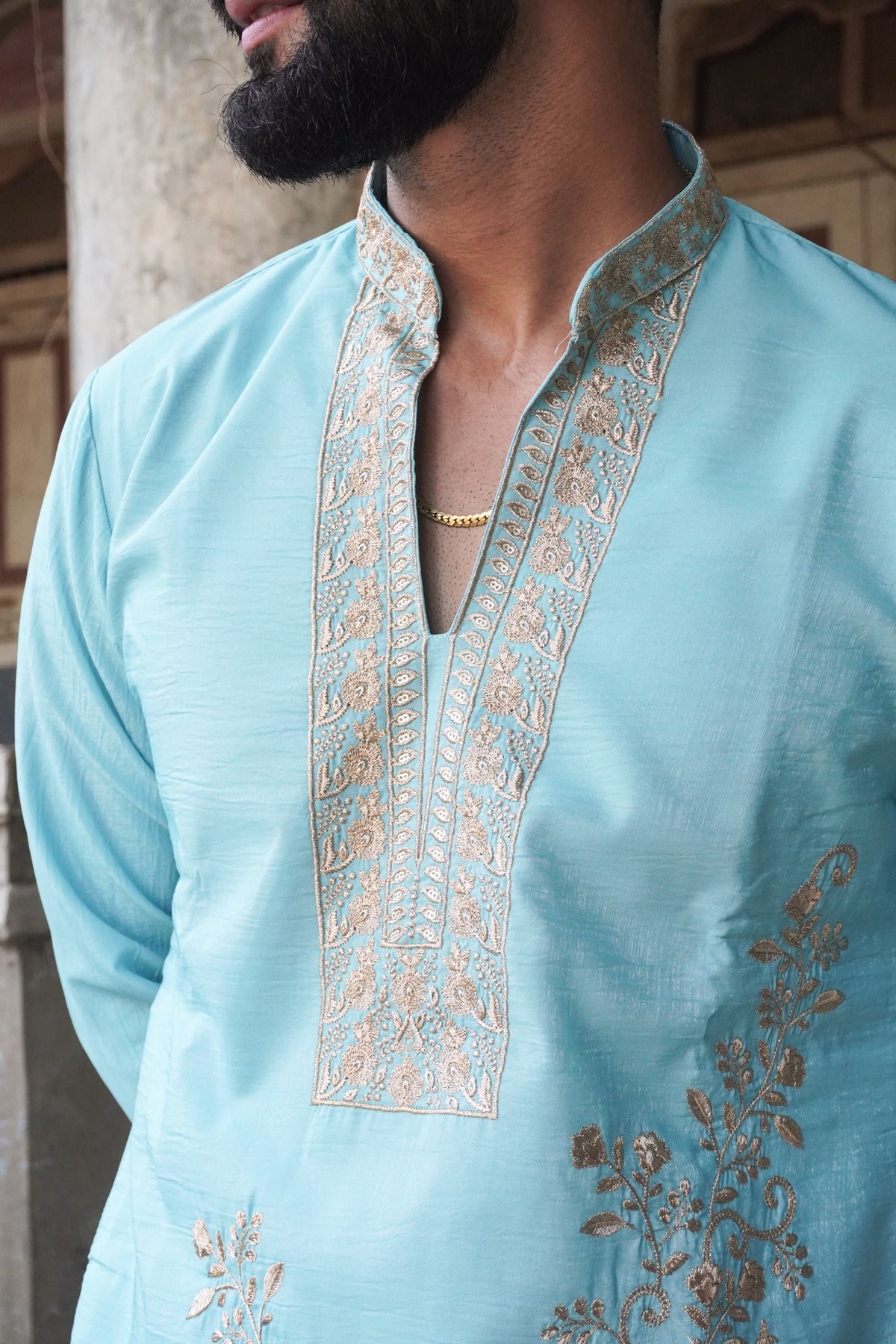 Close-up of embroidered neckline panel on turquoise kurta