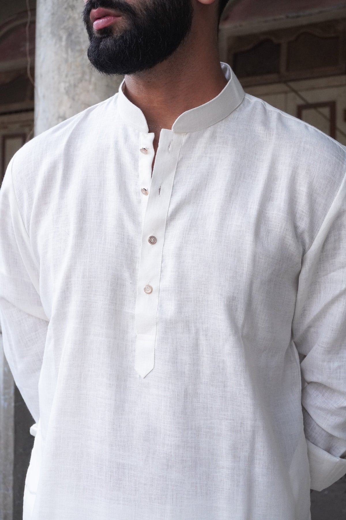 Close-up of band collar and engraved buttons on white kurta