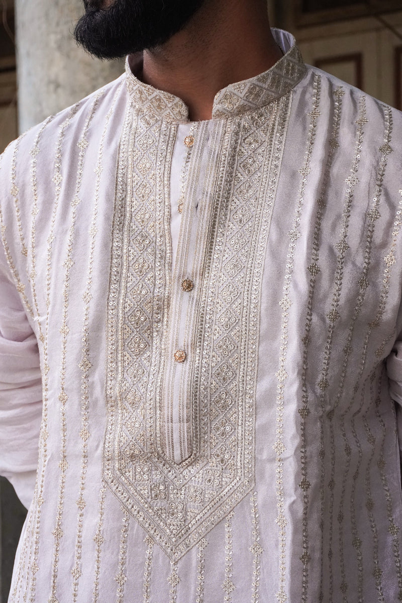 Close-up of embroidered yoke, collar and rose-gold buttons